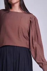 Blusa negra de mangas largas abullonadas y cuello redondo.