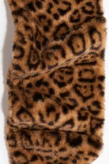 Bufanda confeccionada en tejido suave con efecto peludito, destacando por su diseño con estampado de leopardo en tonos marrones y negros.