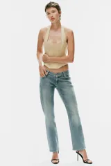 Top estilo corsé color beige, con escote recto, cuello halter y bajo asimétrico. Presenta costuras estructuradas frontales.