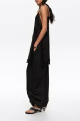 Pantalón jogger negro confeccionado en mezcla de lyocell y algodón, de tiro medio con bolsillos laterales y bajos ajustables mediante cordones elásticos con stoppers.