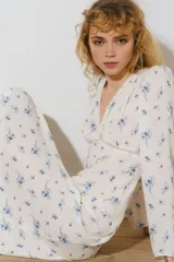 Vestido maxi de viscosa color marfil con estampado floral azul, escote en V pronunciado con ribete de encaje, mangas largas abullonadas y corte entallado.