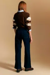 Jean azul oscuro de corte wide leg, con tiro alto, bolsillos frontales tipo parche y bajo deshilachado.