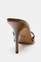 Mule de tacón alto, color marrón (café), con acabado acharolado brillante. Presenta una tira ancha en la parte delantera y punta cuadrada.