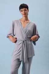Conjunto de dos piezas (camisa y pantalón) de tejido acanalado gris, con camisa estilo kimono de manga ancha y cuello V cruzado, ajustada a la cintura con un lazo de tela.
