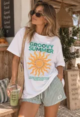 Remerón blanco de corte oversize con estampado frontal de sol y la leyenda "Groovy Summer" en tonos verdes y amarillos.