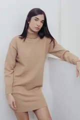 Vestido corto de tejido de punto en color beige, con cuello alto y mangas largas. Presenta puños y ruedo acanalados, con un diseño de calce relajado.
