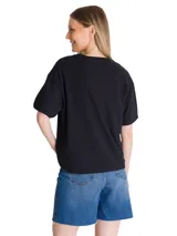 Remera de algodón color negro, con cuello redondo y mangas cortas. Presenta un diseño minimalista con el logo de la marca bordado en el pecho y un parche bordado en la manga izquierda.