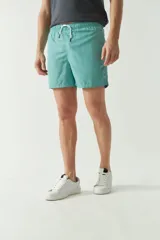 Short de baño liso de secado rápido, con cintura elástica ajustable mediante cordón, dos bolsillos laterales y un bolsillo trasero. Presenta un pequeño logo bordado en la parte inferior.