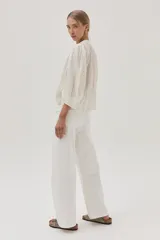 Blusa blanca de algodón con hilos metalizados, cuello mao y escote en V.