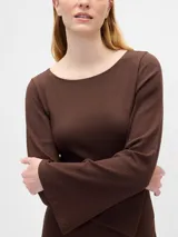 Remera de manga larga con cuello bote, confeccionada en tejido de punto acanalado de textura suave y ajuste entallado.
