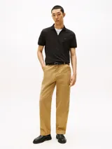 Chomba negra de manga corta con cuello tipo polo y cierre de cremallera corto. Logo de Tommy Hilfiger bordado en el pecho. Confeccionada en algodón orgánico, poliéster reciclado y elastano.