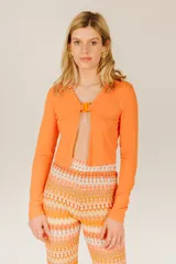 Top corto azul de tejido de punto acanalado, con mangas largas y cierre frontal con hebilla.