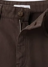 Pantalón de jean de corte recto y tiro medio, con diseño clásico de cinco bolsillos, cierre de botón y cremallera, y trabillas para cinturón.