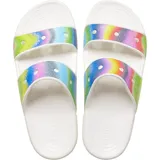 Sandalias Crocs Classic con dos tiras y base blanca. Las tiras tienen un diseño de tinte en aerosol con colores rosa, lila, verde y amarillo.