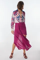 Minifalda fucsia con drapeado lateral y lazo. Asimétrica, confeccionada en lino italiano.