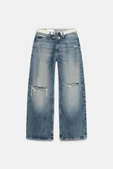 Jeans de tiro medio con diseño de cintura doblada, cinco bolsillos y cierre frontal con cremallera y botón metálico. Presenta un acabado desgastado con roturas en las rodillas y corte recto.