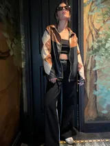 Campera de cuero sintético con cierre frontal, diseño de rombos en tonos marrón, beige y negro.