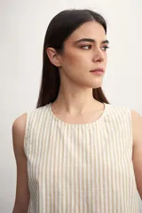 Blusa sin mangas con estampado a rayas verticales color beige y blanco.