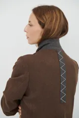 Blazer de corte clásico en color marrón, con cierre frontal de un botón, solapas con muesca y bolsillos laterales. Confeccionado en tejido estructurado.