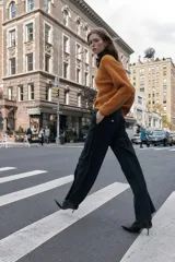 Pantalón de tiro alto color bordó, con pinzas delanteras, bolsillos frontales y falsos bolsillos con solapa en la espalda. Tiene pernera ancha y cierre frontal con cremallera, botón interior y gancho.