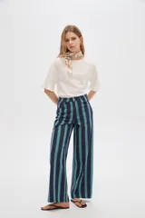 Pantalón jean de tiro alto y corte ancho, con diseño de rayas verticales en tonos azul, verde y marrón.
