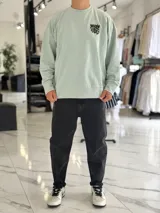 Buzo oversize color beige, con diseño gráfico en la espalda con el texto 'Warm Vibes' en tono marrón y tipografía psicodélica, acompañado de frases secundarias.