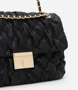Cartera shoulder grande color negro con textura acolchada y cierre con broche metálico dorado. Tiene asa de cadena dorada con apliques de cuero.