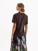 Remera de algodón pima color marrón, con estampa frontal de un conejo rosa sobre un auto con diseño de leopardo. Presenta cuello redondo y mangas cortas.