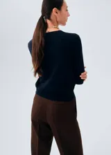 Cardigan de punto fino color azul marino, con cuello en V, manga larga y cierre frontal de botones.
