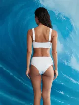 Conjunto de bikini blanco de textura acanalada, compuesto por un top deportivo de escote redondo y tirantes anchos, y una bombacha de tiro alto con cobertura clásica.