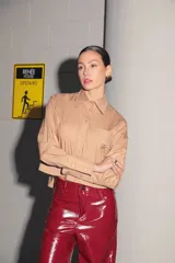 Camisa color camel de poplin de algodón, manga larga y largo a la cintura. Tiene un bolsillo bordado con el isologo de Renée a tono.