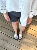 Sandalias chatas de cuero color peltre, fabricadas en Uruguay.