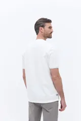 Remera de manga corta con textura, corte regular y cuello redondo. Presenta un diseño bordado en el pecho con motivos botánicos y el logo de la marca Brooksfield.