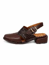 Zapato destalonado de cuero marrón con puntera cerrada, detalles de textura grabada en la capellada y tira ajustable con hebilla en el talón, con taco bajo y ancho.