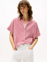 Camisa de manga corta con cuello clásico y cierre frontal con botones. Diseño a rayas verticales rojas y blancas.