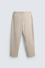 Pantalón de corte regular fit, color negro, confeccionado en tejido elástico. Presenta cintura elástica, cierre frontal con cremallera y botón, bolsillos laterales y bolsillos traseros de vivo.