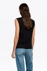 Musculosa negra de corte recto con escote redondo y aplicación de piedras brillantes dispersas por toda la prenda.