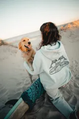 Hoodie celeste con capucha y estampado en la espalda de dos delfines, el logo GW y la frase "Glassy Waves".