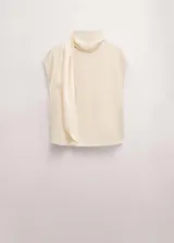 Blusa de seda color crema con cuello alto y detalle de pañuelo integrado en el escote. Presenta un diseño fluido y elegante de manga larga.
