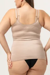 Camiseta modeladora color piel, confeccionada en lycra reforzada con tela de faja en la zona abdominal. Cuenta con breteles regulables y escote redondo.