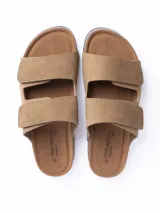 Sandalia de dos tiras con cierre de velcro, confeccionada en material símil cuero color gris. Cuenta con plantilla anatómica con base de corcho y suela de goma negra.