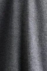 Remera de manga larga en punto fino color gris oscuro, con cuello polo y tapeta de botones. Presenta hombros ligeramente caídos y remates acanalados en puños y bajo.