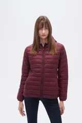 Campera acolchada tipo puffer, color beige claro, con capucha y cierre frontal. Presenta costuras horizontales y un calce entallado.