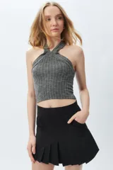 Top sin mangas de cuello halter cruzado, de morley color gris, ajustado al cuerpo y con textura acanalada.
