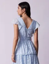 Vestido midi celeste de gasa estampada, marca Julia Jordan. Tiene escote en V, mangas cortas con volados y forro interno a tono.