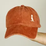 Gorra de béisbol de jean color naranja con bordado blanco en el frente. Cuenta con visera curva y ajuste posterior.