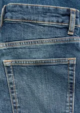 Jeans slim tiro alto de color azul, con diseño crop, cierre de botón y cremallera, trabillas y cinco bolsillos.