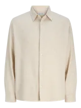 Camisa de manga larga con cuello clásico y calce relajado, confeccionada en tejido jacquard texturizado. Presenta un diseño de color beige con cierre frontal de botones y puños sencillos.