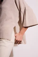 Sweater color beige de tejido de punto, con cuello redondo y mangas 3/4 con volados.