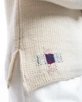 Sweater color crema de lana merino con cuello bote y mangas largas.